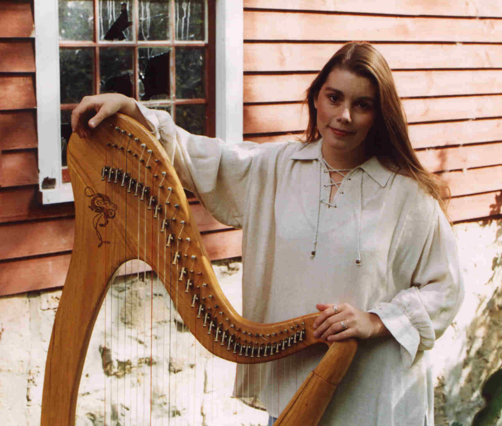 Jennifer and her harp, in front a window of the old mill in Otterville, Ontario, Canada